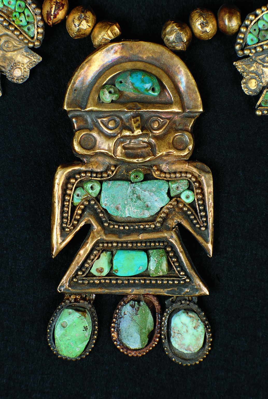 un pendentif avec des incrustations de turquoise