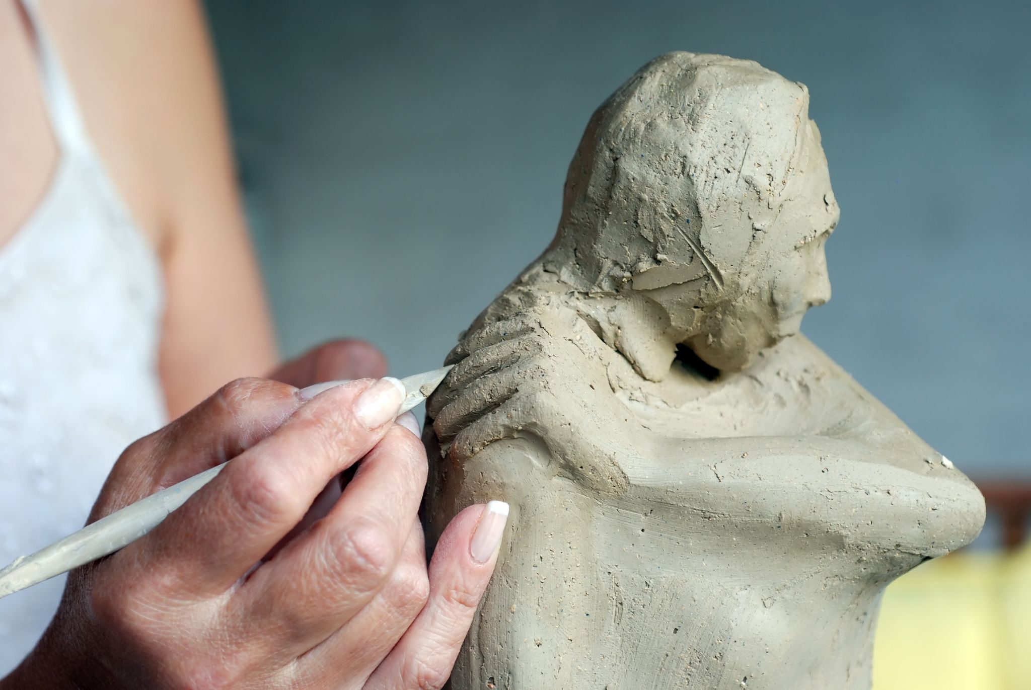 une artiste réalisant une sculpture en argile