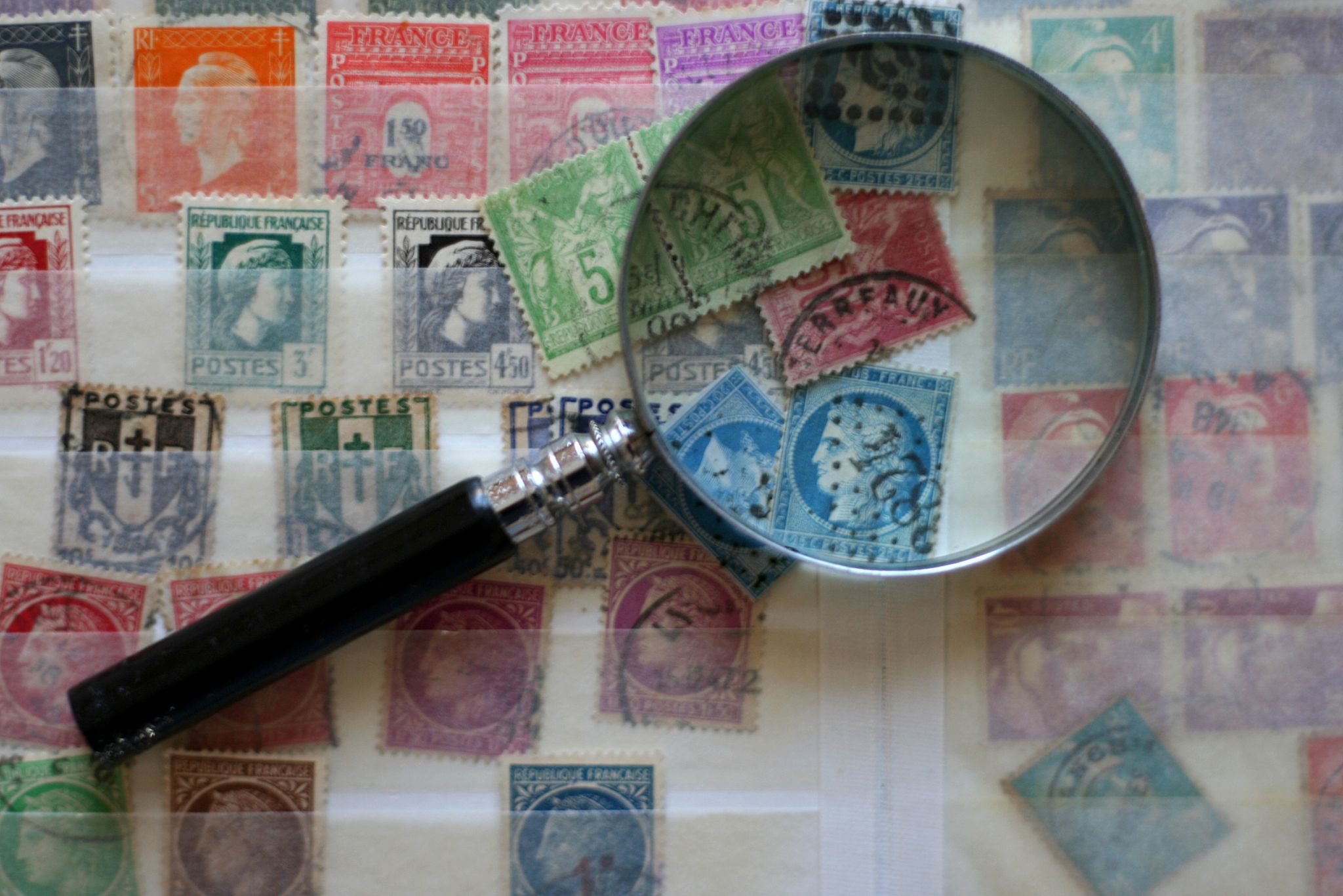 une collection de timbres observée à la loupe