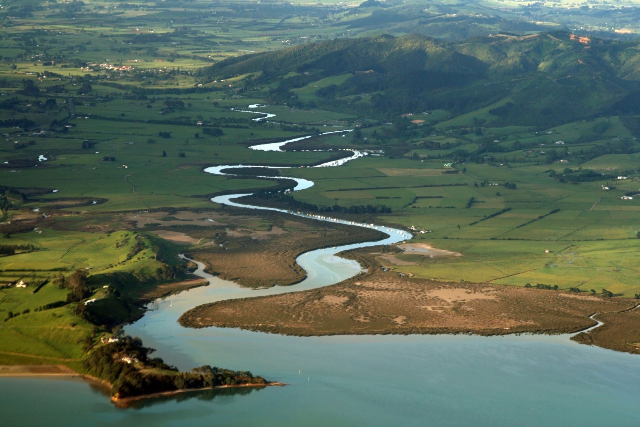 les méandres d’une rivière sinueuse et son embouchure sur un lac (Nouvelle-Zélande)