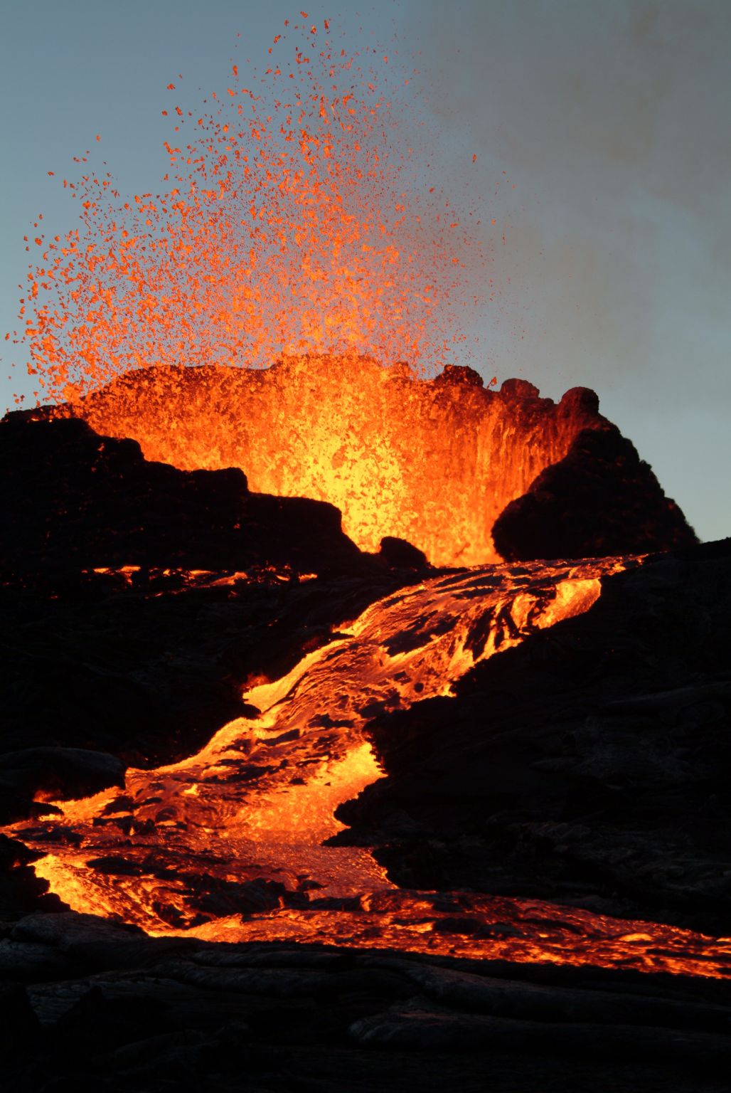 un volcan et sa coulée de lave (roches en fusion)