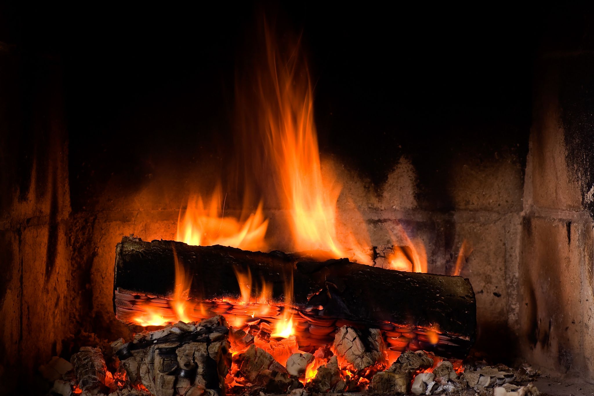des bûches se consumant dans l’âtre de la cheminée et produisant des cendres